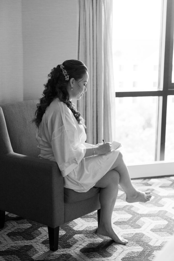 black and white of bride writing vows to groom, mill lake wedding in spring lake new jersey