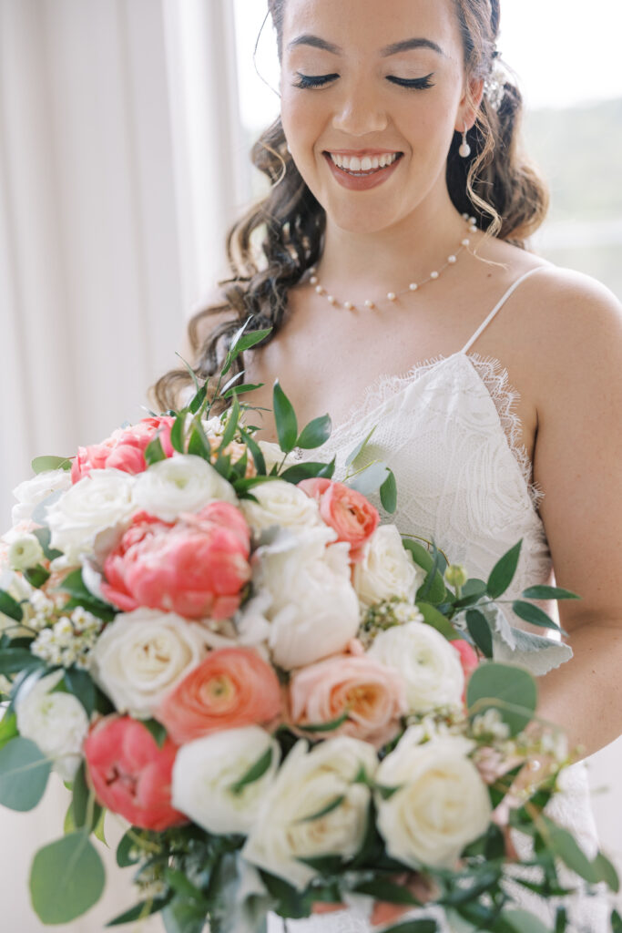 bride laughing while holding her bouquet