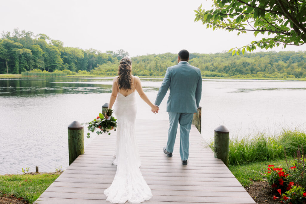 Couple walking on the dock at their The Mill Lakeside Manor Wedding