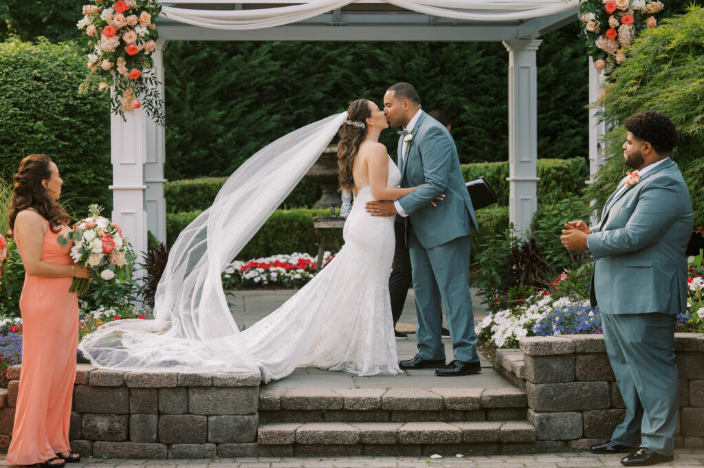 bride and groom kiss during wedding ceremony at The Mill Lakeside Manor