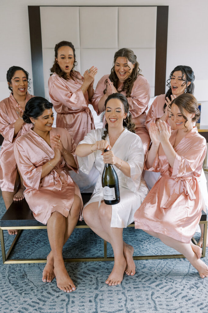 champagne toast with bridal party getting ready in matching robes at for a mill lake wedding in spring lake new jersey