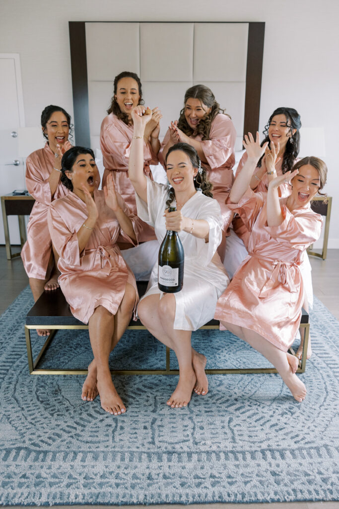 champagne toast with bridal party getting ready in matching robes at for a mill lake wedding in spring lake new jersey