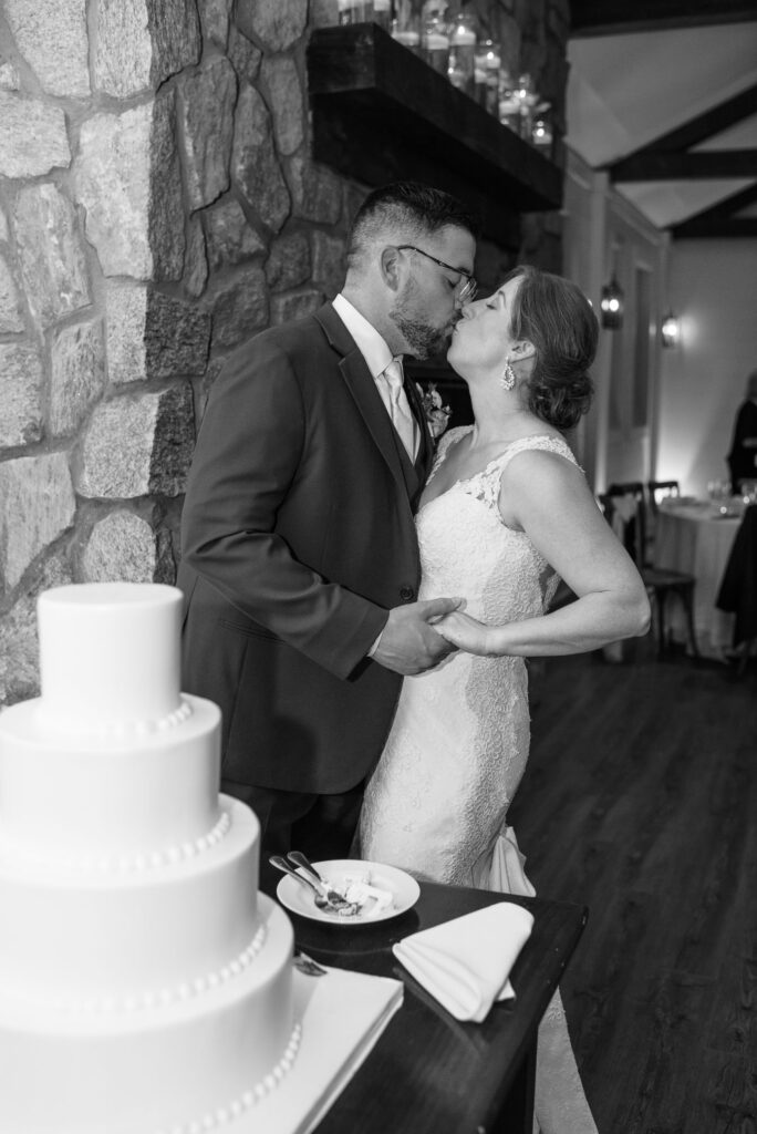 Black and white photo of couple during cutting the cake