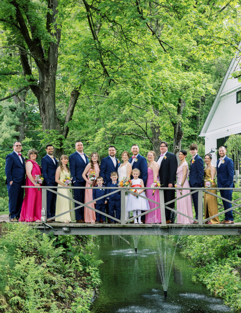 Wedding party standing on bridge at Millrace Pond