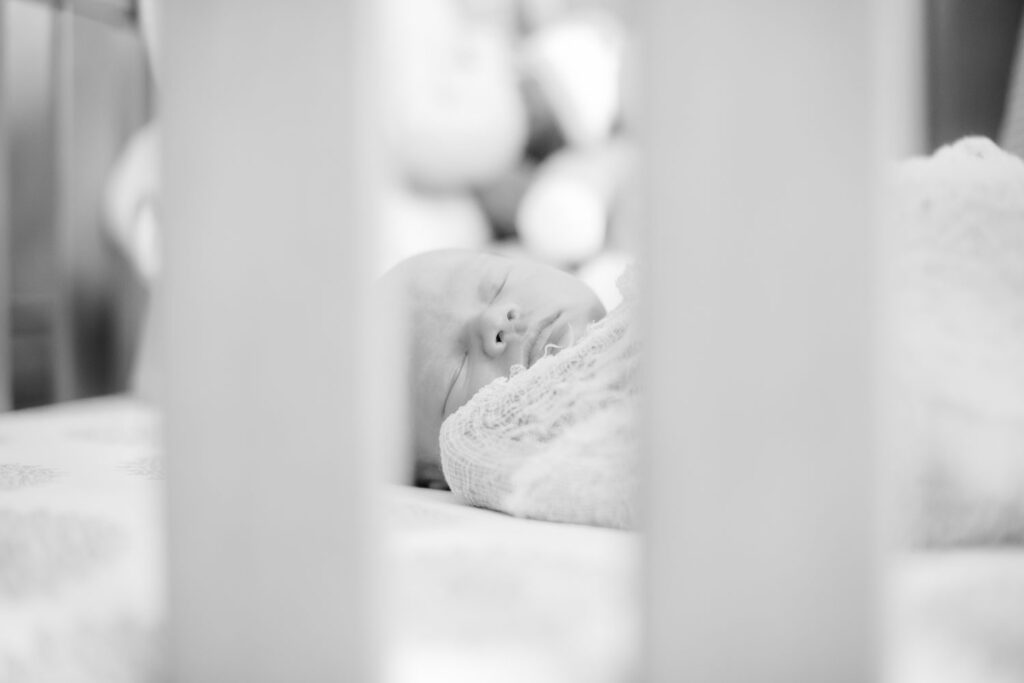 newborn in crib sleeping during photo session