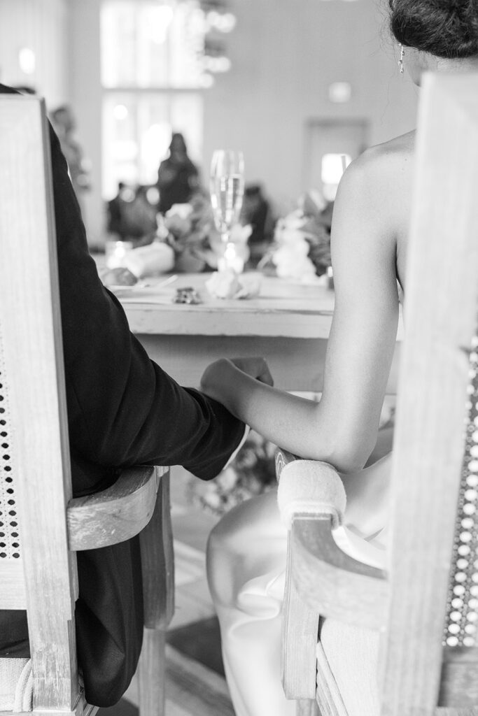 black and white image of couple holding hands during speeches 