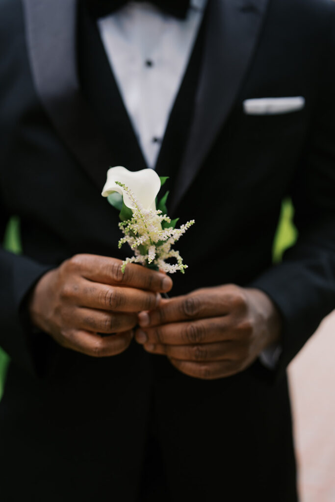 Groom holding boutonniere at Ryland Inn, New Jersey with photos by Simone Jaramillo Photography