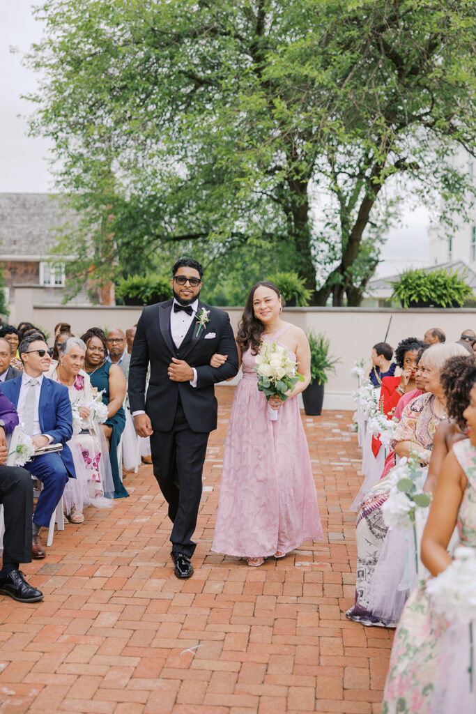 Maid of honor and best man walking down aisle for ceremony at the Ryland Inn