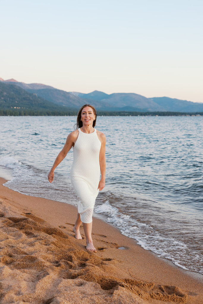mom portrait while shes walking along beach in Lake Tahoe in white dress