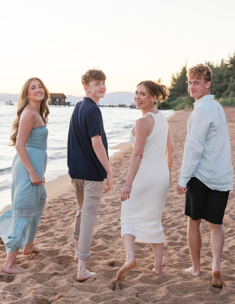 family walking photo, turn and looking behind them on a beach in Lake Tahoe