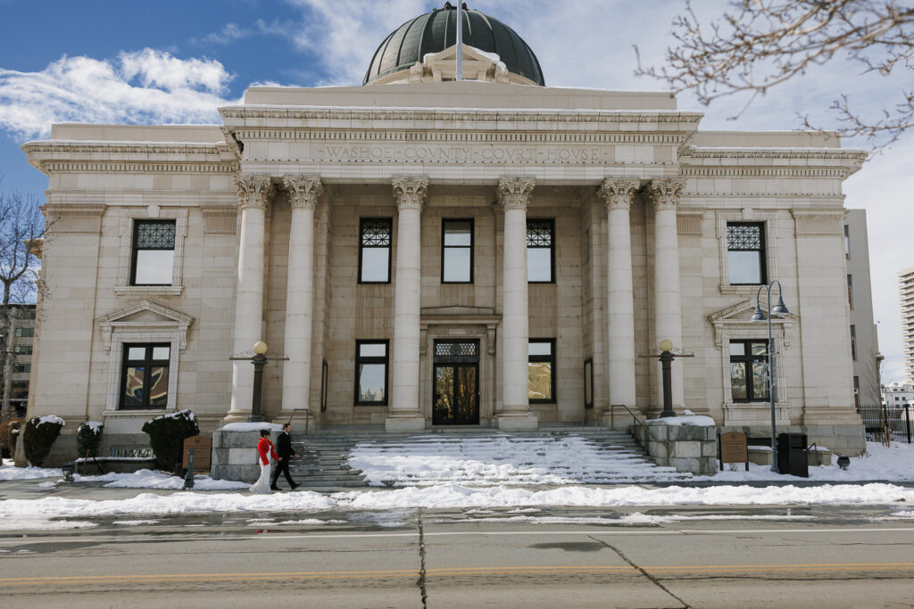 Reno couple walking in front of the washoe county courthouse for engagement photos with Simone Jaramillo Photography.
